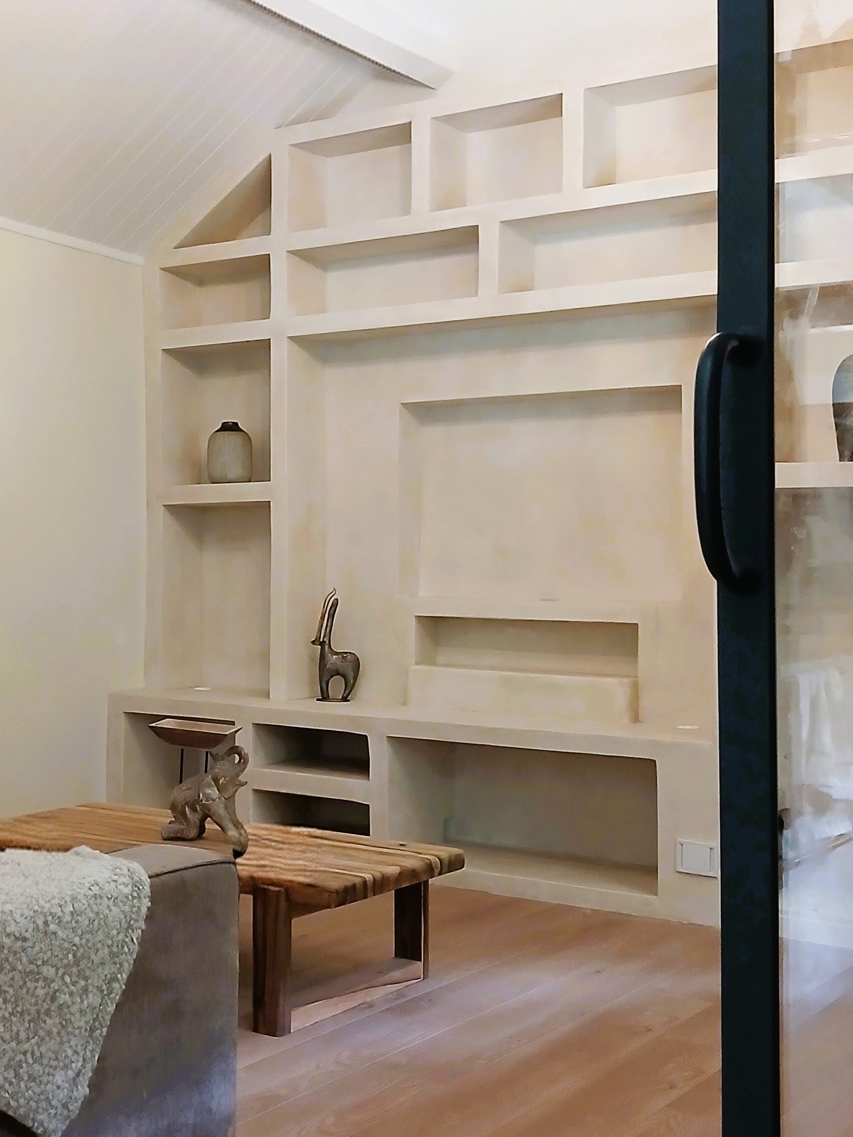 Mobilier maçonné en béton cellulaire avec niches et rangements sur mesure dans un salon