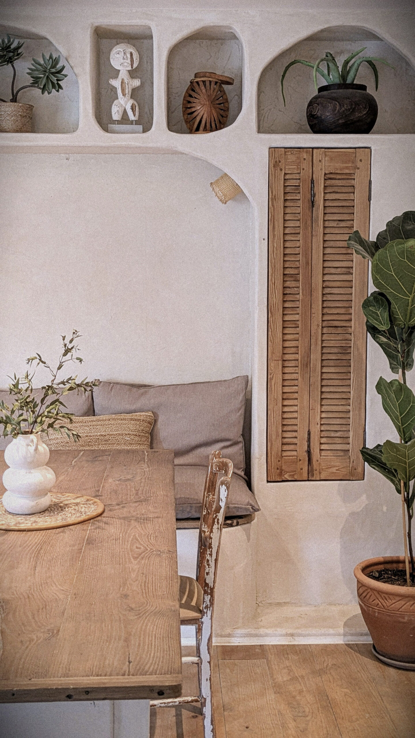 Banquette maçonnée intégrée avec porte persienne sublimée dans un intérieur chaleureux par L’Établi de Fanny